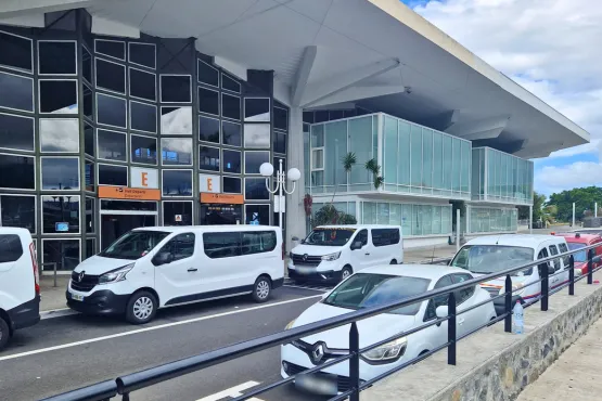 minibus de go taxi vtc la reunion stationnant devant entree aeroport roland garros pour transfert